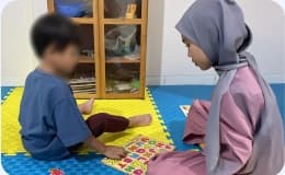 Teacher guiding child during interactive early intervention
