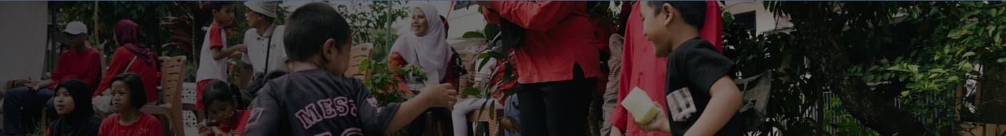 Community volunteers, teachers, and children participating together in garden learning session